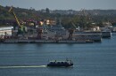 A ferry boat navigates across Havana Bay as it passes Cuban coast guard ships docked at the port as it leaves Casablanca, Cuba, Thursday, Feb. 26, 2026.