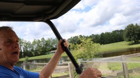 Paul Gregory, who runs Mill Creek Farm horse sanctuary in Alachua, drives over muddy ground on Thursday. Flooding from Hurricane Irma’s rains overtook much of the farm’s land, and some, like in the pasture behind Gregory, is still under water. (Darcy Schild/WUFT News)