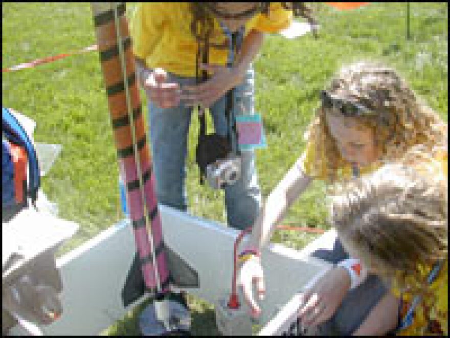 The rocket girls from Grand Forks, N.D. -- twin sisters Courtney and Sarah Thaden and friend Bryn Putbrese (upper left) -- set up their rocket, the Lucky Lady, at the launch pad.