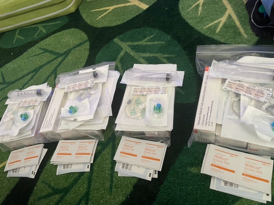 One week's worth of infusions rests on a carpet prior to Kamila's weekly routine of receiving the medication. One week of infusions costs $15,000, said Kamila's mother, Breana Dion.