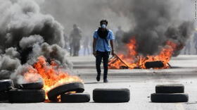 A Nicaraguan protester walks among burning barricades during political unrest in Managua this summer.