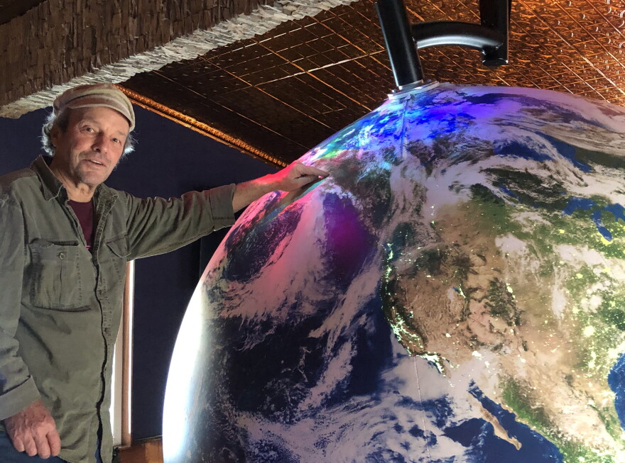Artist Eric James Morris points out Fairbanks on a giant spherical model of Earth at the soon-to-be opened Aurora Discovery Institute at Pike's Waterfront Lodge in Fairbanks.