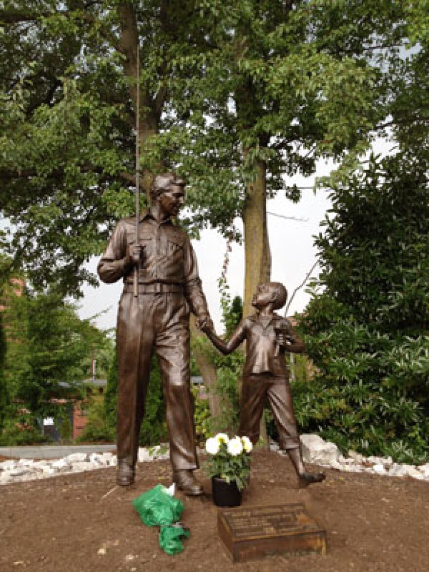 Flowers have been placed at the statue outside the Andy Griffith Playhouse in Mount Airy, NC. Photo: Tanner Latham