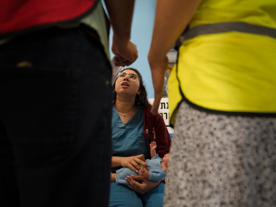 Lipaz Zira play acts as a patient with a baby in a drill in the underground hospital in Haifa.