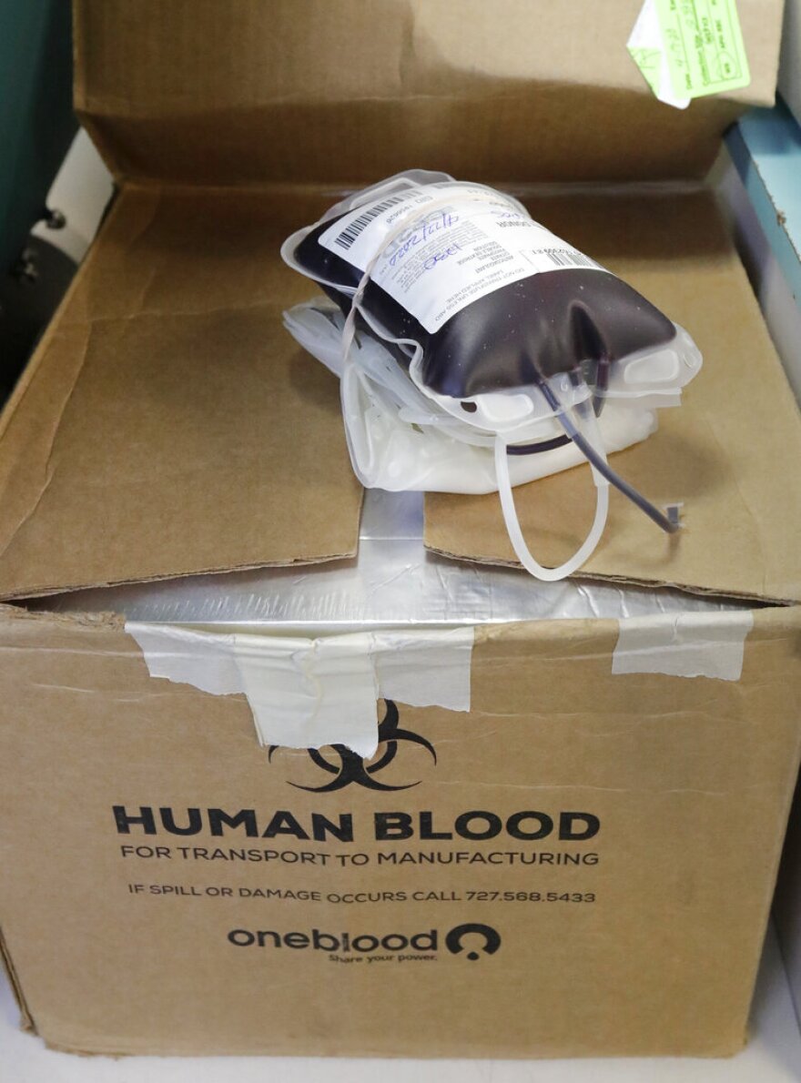 A bag of newly donated blood sits on top of a storage box aboard a OneBlood blood donation bus