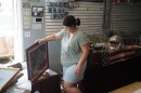 Kaylyn Boyd carries a framed photograph from her father's flooded sports card shop in Cambridge City, Ind., Thursday, Aug. 13, 2026.