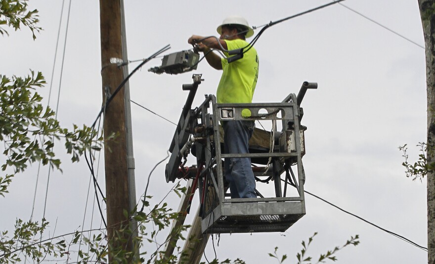 Utility crews work to restore services in Saucier, Miss., Sunday, Sept. 4, 2011 after high winds toppled trees and flipped trailers. Tropical Storm Lee is continuing to meander along the Gulf Coast bringing torrential rains and flooding. (AP Photo/Dave Martin)