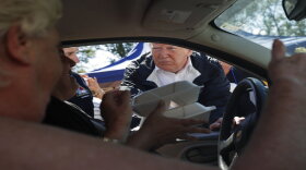 President Donald Trump and North Carolina Gov. Roy Cooper, left, hand out food at Temple Baptist Church, where food and other supplies are being distributed during Hurricane Florence recovery efforts, Wednesday, Sept. 19, 2018, in New Bern