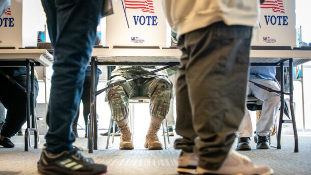 FILE - Voters on Election Day, including one in military uniform, at the busy Centre Point polling station in Aurora, Nov. 5, 2024.
