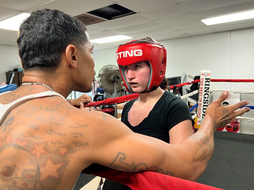  A coach talks with a boxer as she's about to step into the ring.