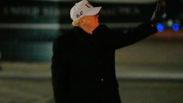 President Donald Trump gestures to a person walking down the stairs behind him as he arrives on Air Force One, Tuesday, Jan. 27, 2026, at Joint Base Andrews, Md., after returning from a trip to Iowa. (AP Photo/Mark Schiefelbein)
