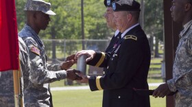 Gen. William J. Gothard (right) receives a spent shell casing as part of his 2014 retirement ceremony at Fort Jackson, S.C.  Gothard says his 36 years of service left him with hearing loss and tinnitus.