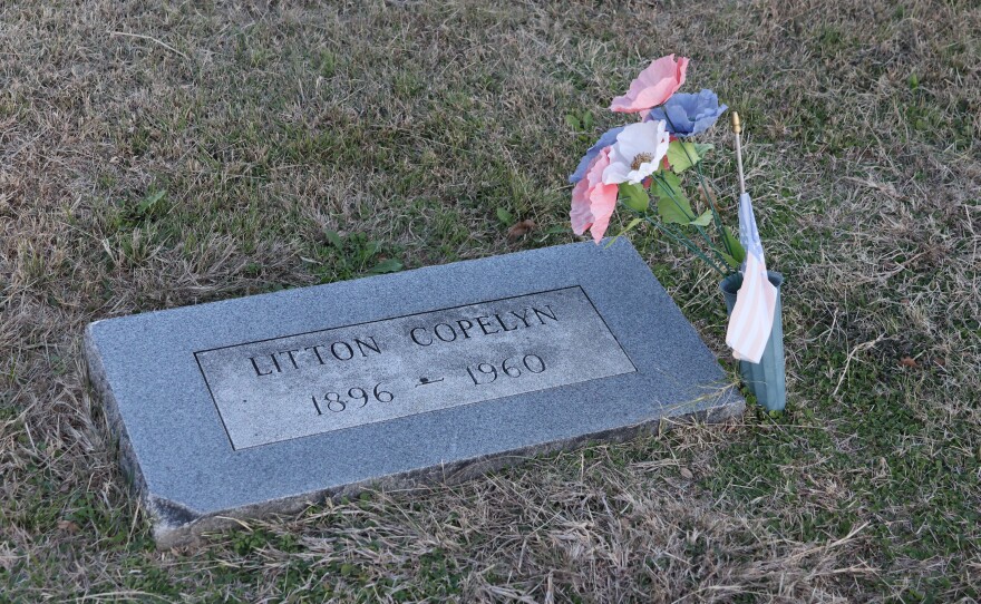 The grave marker for Litton Copelyn -- who died in 1960. Pink, white and violet flowers are planted next to his marker. 