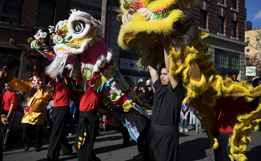 Members of the Master David F. Leong Dragon & Lion Group walk  after performing the Lion Dance during the Lunar New Year celebration on Sunday, Feb. 11, 2018, in the Chinatown-International District in Seattle.