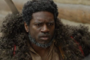 Close-up of a Black man wearing some sort of fur coat.