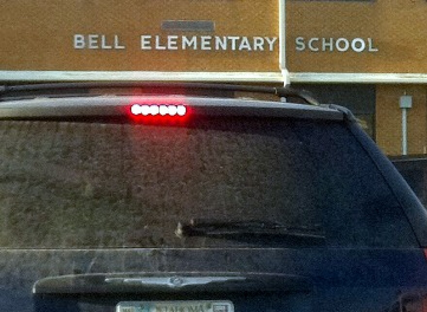 A car stops in front of Bell Elementary so that the driver can sign a petition.