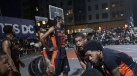 Snuff 317 team member Dereck Seals, Jr., second from right, talks with his team on the bench during a Goodman League basketball game Tuesday, June 24, 2025, in the Barry Farm neighborhood of Washington. (AP Photo/Rod Lamkey, Jr.)