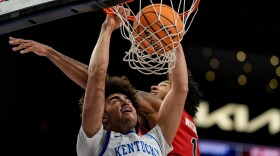 Kentucky center Malachi Moreno (24) dunks against St. John's forward Dillon Mitchell (1) during the first half of an NCAA basketball game, Saturday, Dec. 20, 2025, in Atlanta. (AP Photo/Mike Stewart)