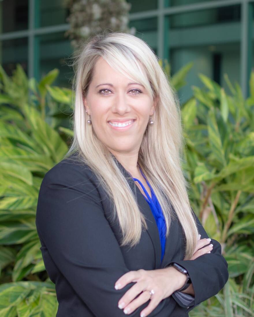 Jenn Petion, CEO, Family Support Services stands in front of a building smiling.