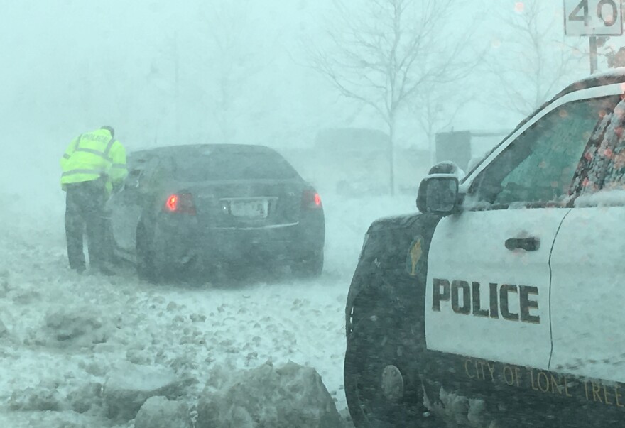 A policeman in Lone Tree, Colo., talks to a driver as snow clogs the towns roads, caught in a later winter storm known as a bomb cyclone.