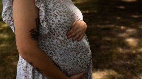 A pregnant person holds their stomach on Tuesday, June 25, 2024 at Downtown in Luray, Virginia.