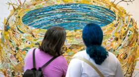 Two festivalgoers look at a piece of art during the 2022 Coconut Grove Arts Festival.