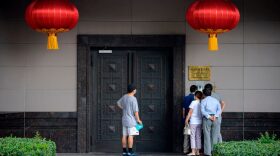 People attempt to talk to someone at the Chinese consulate in Houston on July 22, 2020. (Photo by MARK FELIX/AFP /AFP via Getty Images)