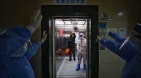 Medical staff wave goodbye to a recovered COVID-19 coronavirus patient at the Red Cross Hospital in Wuhan in China's central Hubei province on March 16, 2020. (STR/AFP via Getty Images)