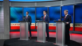 Frank LaRose, Bernie Moreno and Matt Dolan stand behind individual podiums on a TV stage against a red, white and blue background.