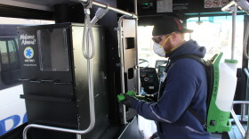 An unidentified worker sprays the inside of a bus.