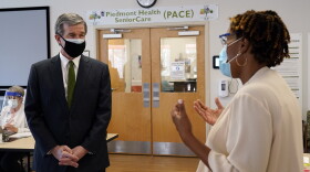 Gov. Roy Cooper, left, speaks with Misty Drake, Chief Operating Officer at Piedmont Health Senior Care, a federally qualified health center where PACE patients (Program of All-Inclusive Care for the Elderly) and underserved populations can receive the COVID-19 vaccine Thursday, Jan. 28, 2021 in Pittsboro, N.C. 
