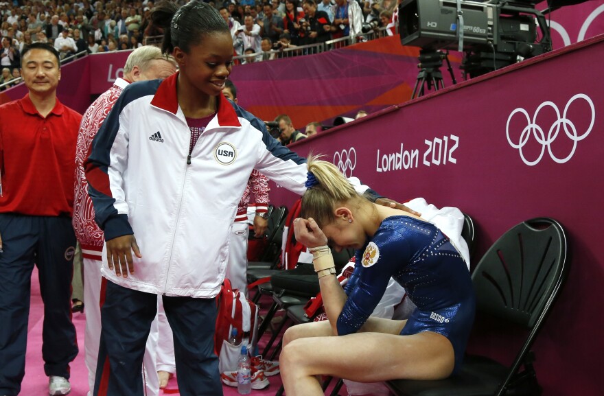 After Thursday's competition, American Gabby Douglas consoles silver medalist Victoria Komova of Russia.
