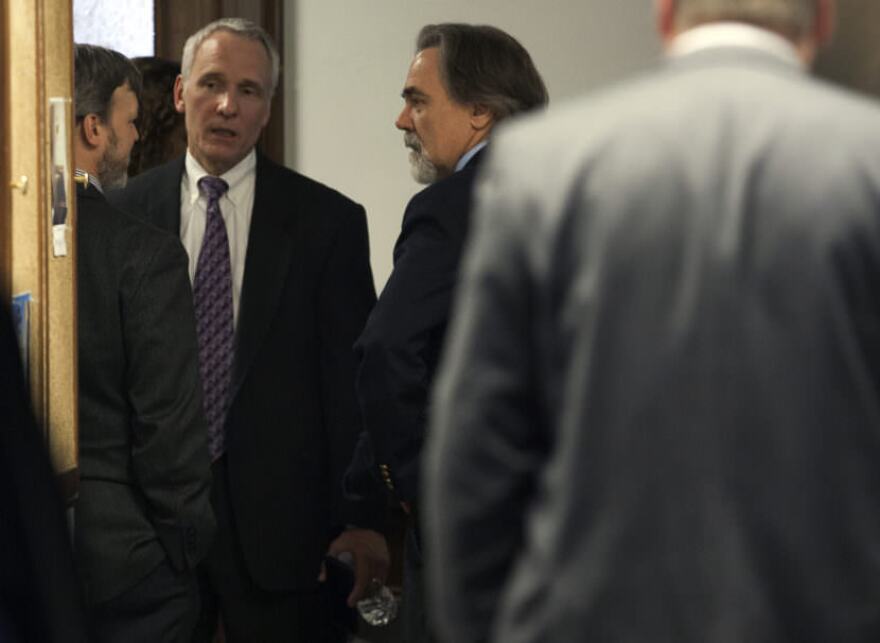Lobbyists Kevin Jardell and Dan Seckers talk to Alaska Department of Revenue Commissioner Randall Hoffbeck during a break in a hearing on a state House oil tax credit bill on Wednesday, in Juneau, Alaska. (Photo by Rashah McChesney/Alaska’s Energy Desk)