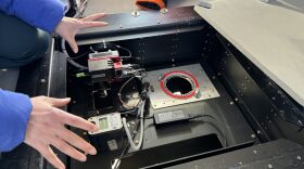 Chief Scientist of Arctic AIR, Jiaxu Zhang, demonstrates the instruments used in the project's modular bay on a NOAA Twin Otter aircraft.