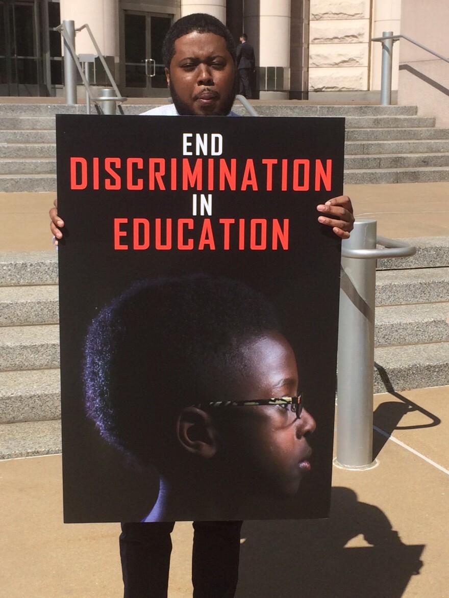 Edmund Lee Sr. holds a poster picturing his son outside the federal courthouse downtown on May 4, 2016.