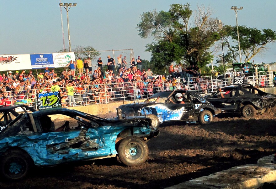 Travis Moyer (center) drives the car that he built for the demolition derby in Kansas.