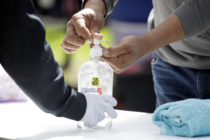 Hand sanitizer is dispensed at a mobile shower service provided by The Shower of Hope in MacArthur Park in Los Angeles on March 23, 2020.