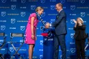 Major League Soccer Commissioner Don Garber drapes an MLS scarf that reads "St. Louis" over Carolyn Kindle Betz, who leads the ownership group for St. Louis' new professional soccer team. Tuesday, Aug. 20, 2019