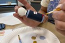 painting a blue wooden doll
