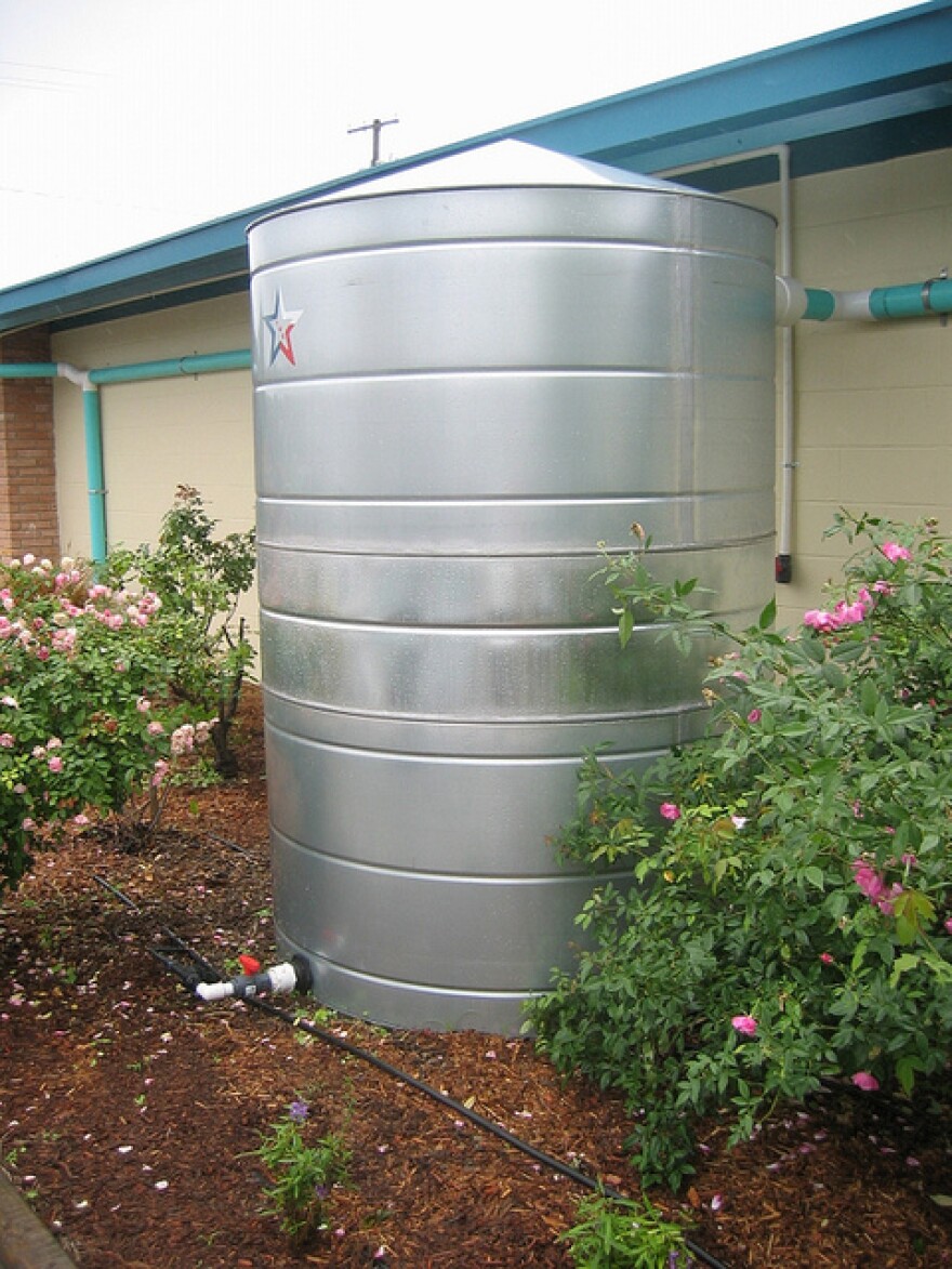 Rainwater can be harvested and stored in plastic or metal tanks, like this collection tank which provides water used to irrigate a nearby garden.