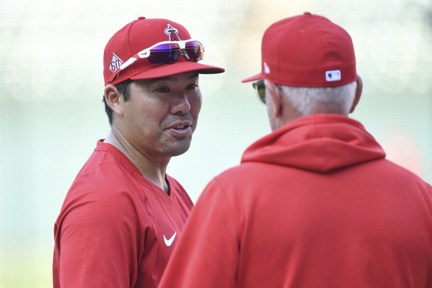 FILE - Los Angeles Angels' Kurt Suzuki, left, talks with Los Angeles Angels manager Joe Maddon during batting practice before a baseball game against the Baltimore Orioles, Tuesday, Aug. 24, 2021, in Baltimore.