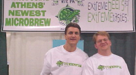 Two men wearing Terrapin T-shirts pose in front of a promotional banner introducing the Athens microbrewery.