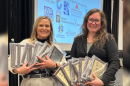 CEO/General Manager Sarah Bignall and News Director Chelsey Perkins hold the 18 Eric Sevareid Awards earned by the KAXE News team at the Midwest Broadcast Journalism Association's 2026 awards banquet April 11, 2026, at the InterContinental St. Paul Riverfront hotel.