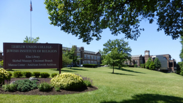 brick building on lush green hill with college sign in front: Hebrew Union College