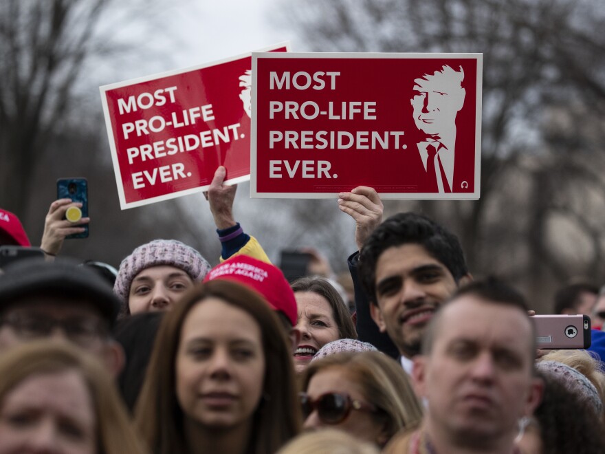 Supporters listen and hold signs as President Trump speaks during the annual March for Life rally on the National Mall in Washington, D.C., on Friday.