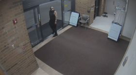A man with bandages on his face wearing a black tank top is seen looking back while exiting Trinity Health Hospital in Ann Arbor, Michigan.