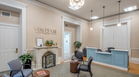 The interior of an office that has a metal sculpture of the wall that says "Vera House."