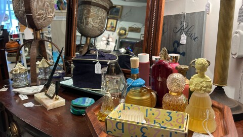 A set of antique perfume bottles are displayed atop an antique desk at Bond’s Vintage Vault in Micanopy. (Lily Perkins/WUFT News)