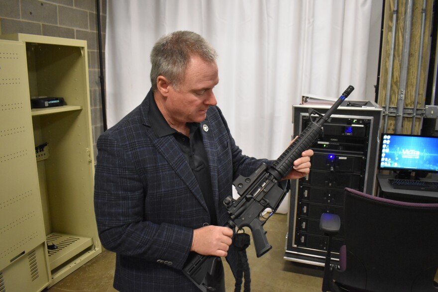 Brian Fengel, director of the Central Illinois Police Training Center, holds a VR rifle used with the VirTra police training simulator.