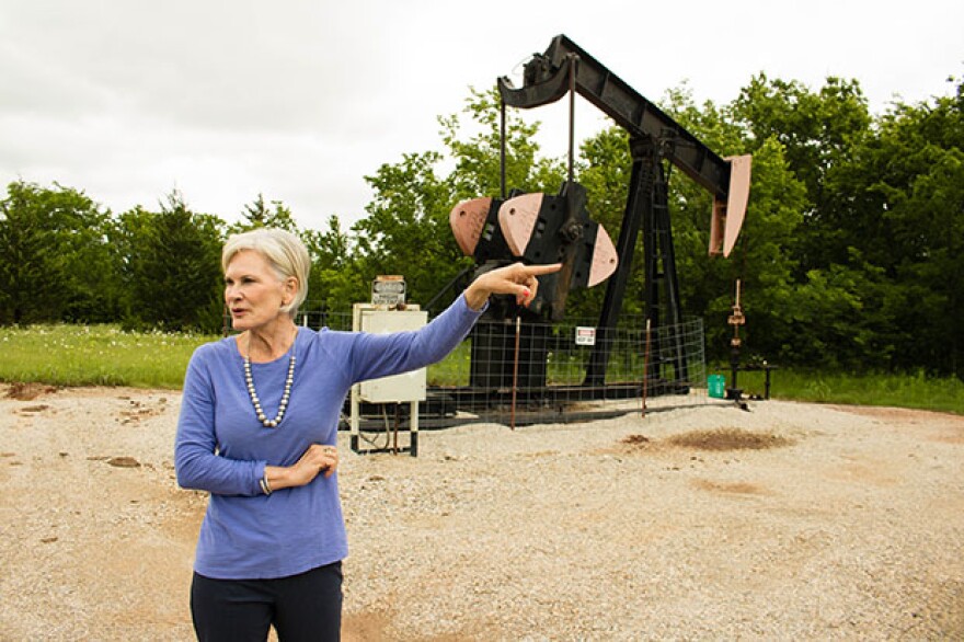 Columbus Oil Company owner Darlene Wallace in the field with a "stripper well," which produces two-and-a-half barrels of oil a day. 
